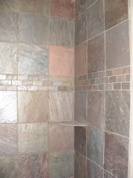 A tiled shower with a mosaic tile pattern.