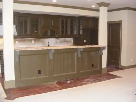 A kitchen with brown cabinets and white counters.