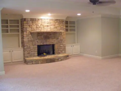 A room with a fireplace and a large white wall.