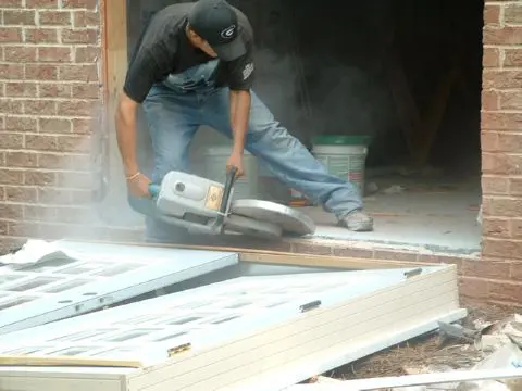 A man using a circular saw to cut wood.