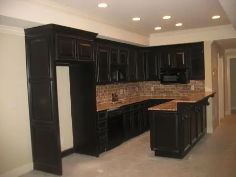 A kitchen with black cabinets and granite counter tops.
