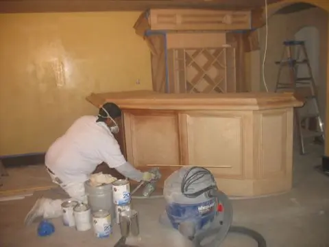 A person sanding in front of a counter.