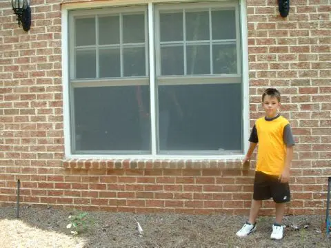 A boy standing in front of a window.