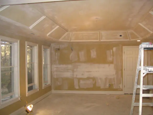 A room with walls and ceilings being remodeled.