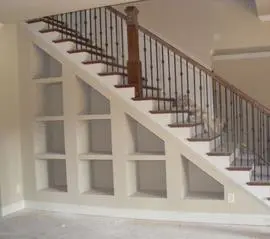 A staircase with metal railing and white walls.