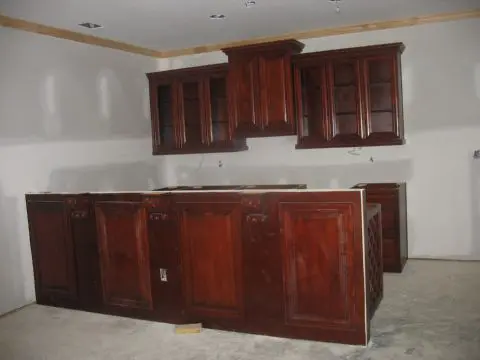 A kitchen with wooden cabinets and white walls.
