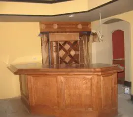 A wooden bar with a wine rack on top of it.