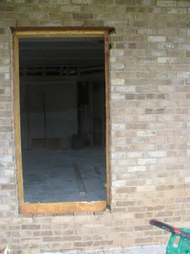 A brick wall with a window in the middle of it