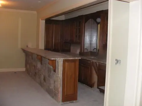A room with a bar and cabinets in it