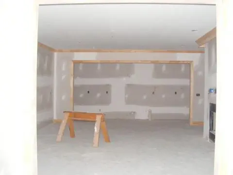 A room with walls being built and the floor is in place.