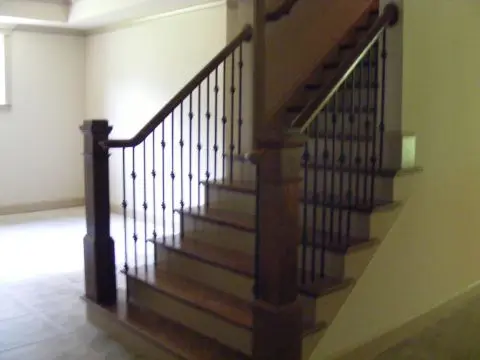 A staircase with metal railing and wood steps.