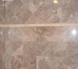 A close up of the marble floor with a wooden strip