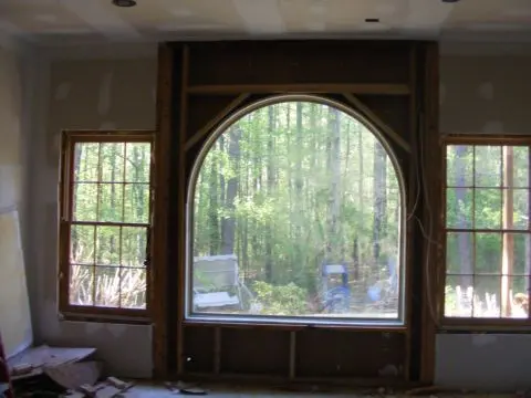 A room with a large window and trees in the background.