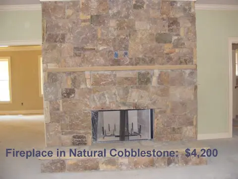 A fireplace in natural cobblestone is shown.