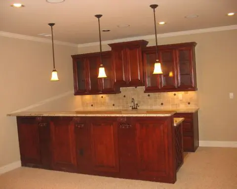 A kitchen with wooden cabinets and marble counter tops.