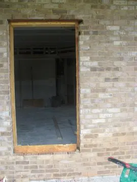 A brick wall with a door and window in it