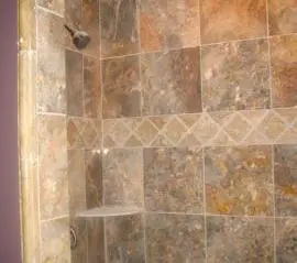 A tiled shower with a tile floor and walls.
