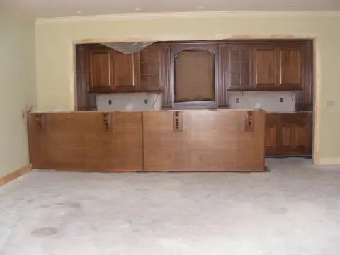 A kitchen with wooden cabinets and a large counter.