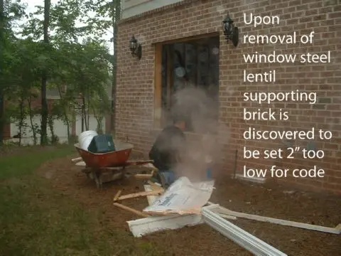 A man is working on the outside of a house.