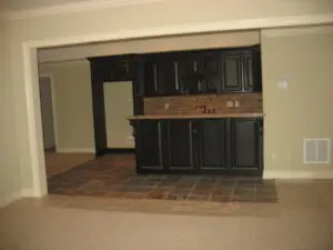 A kitchen with black cabinets and brown counter tops.