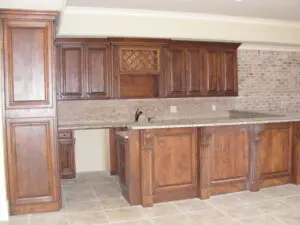 A kitchen with wooden cabinets and tile floors.