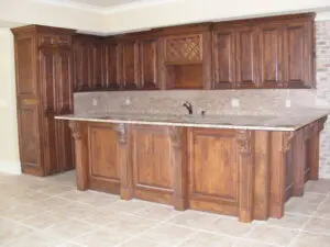 A kitchen with wooden cabinets and tile floors.