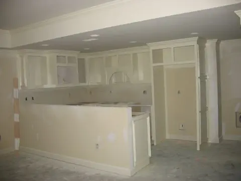 A kitchen with white walls and cabinets in it