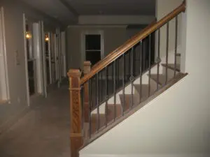 A wooden staircase with metal railing in the middle of it.