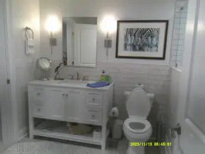 A bathroom with white tile and a toilet.